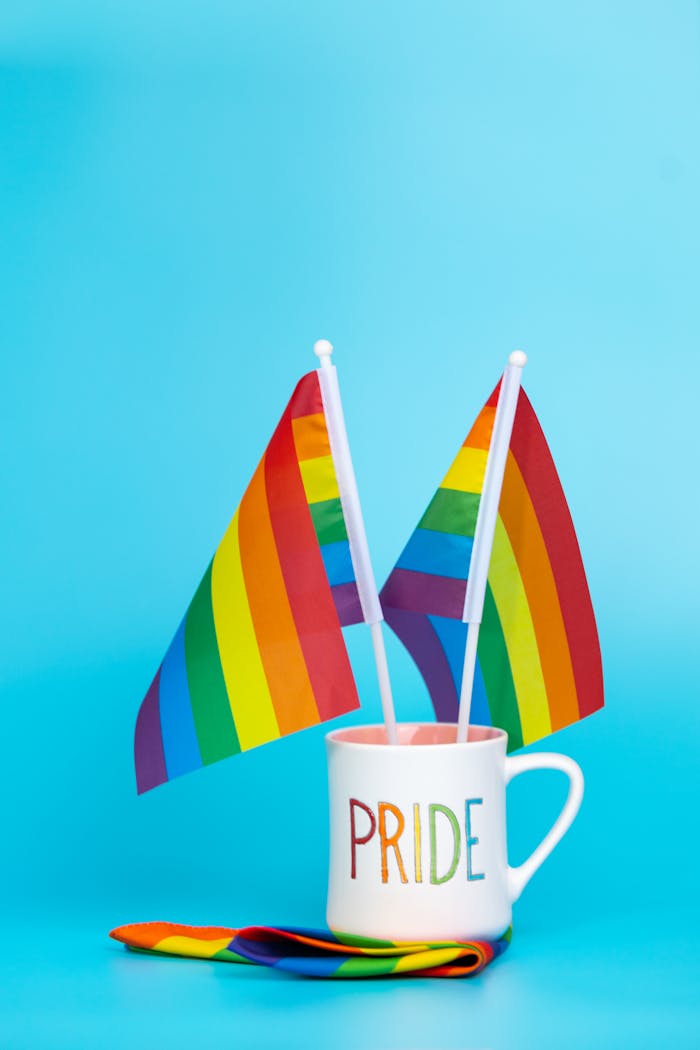 ours-journey Colorful rainbow flags in a mug with pride text on a blue background.